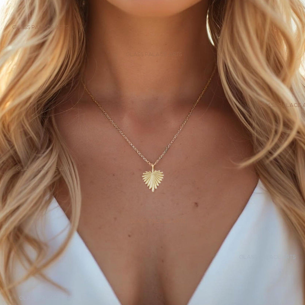 Woman wearing a gold necklace with a heart-shaped pendant, blurred background