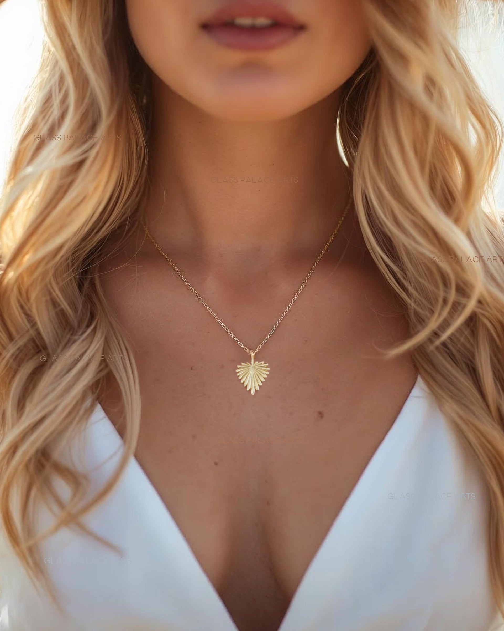 Woman wearing a gold necklace with a heart-shaped pendant, blurred background