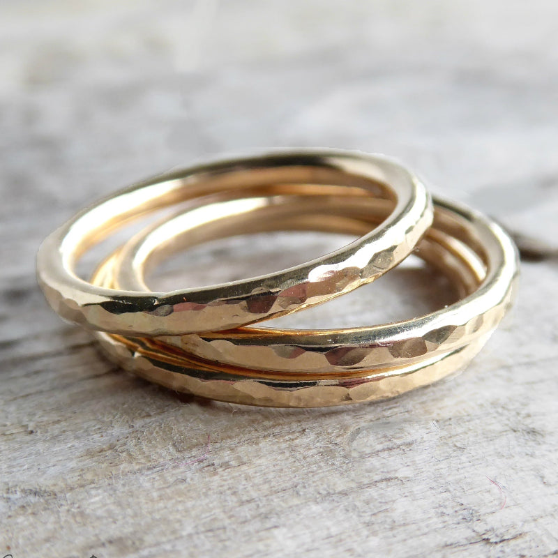 hammered gold rings on grey background