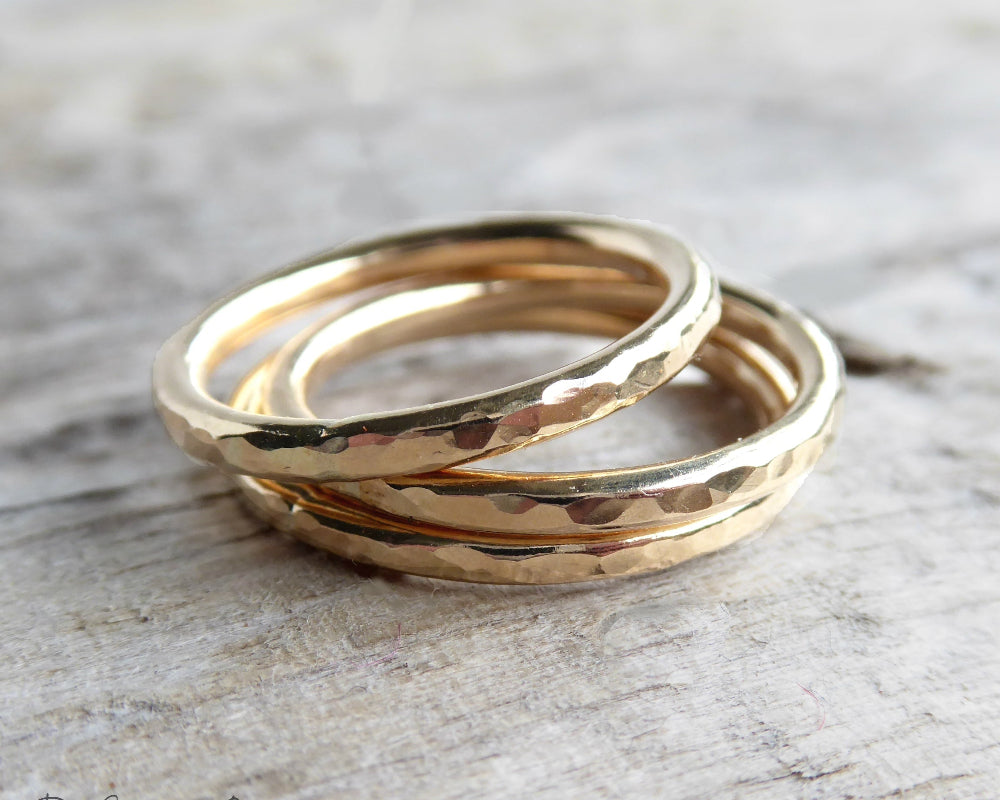 hammered gold rings on grey background