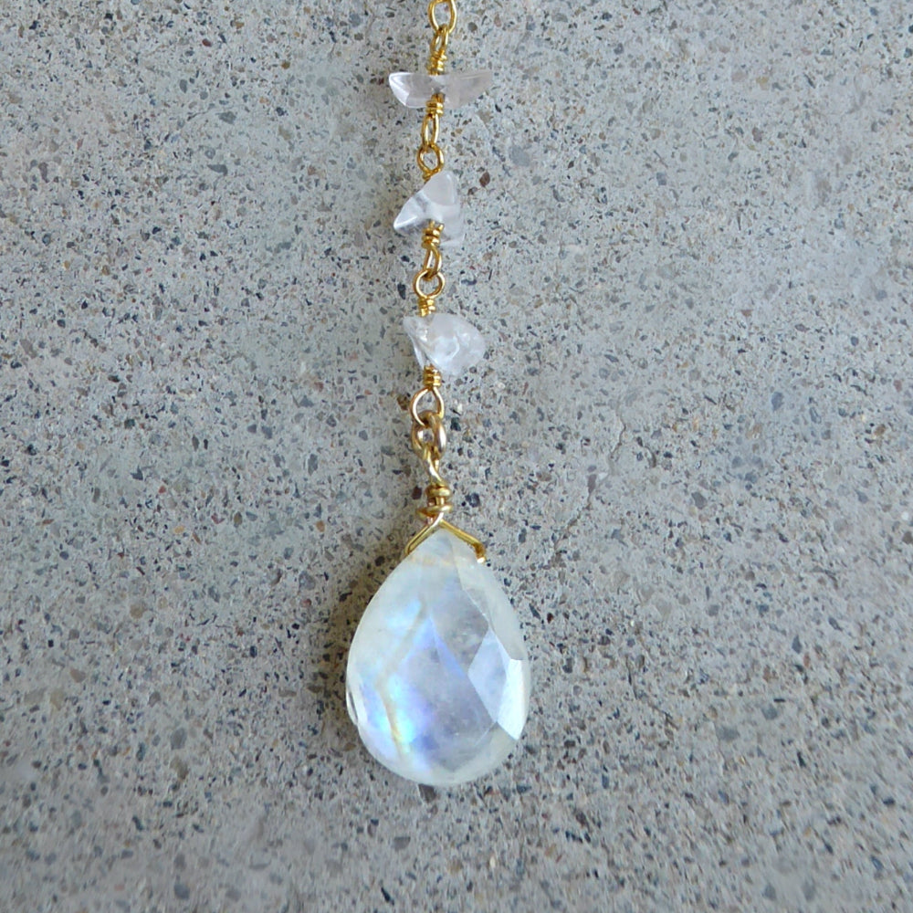 large moonstone focal pendant on gold chain with grey background