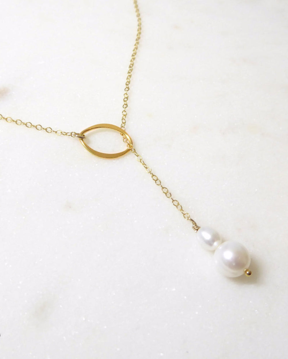 Gold necklace with pearl pendants on a white background