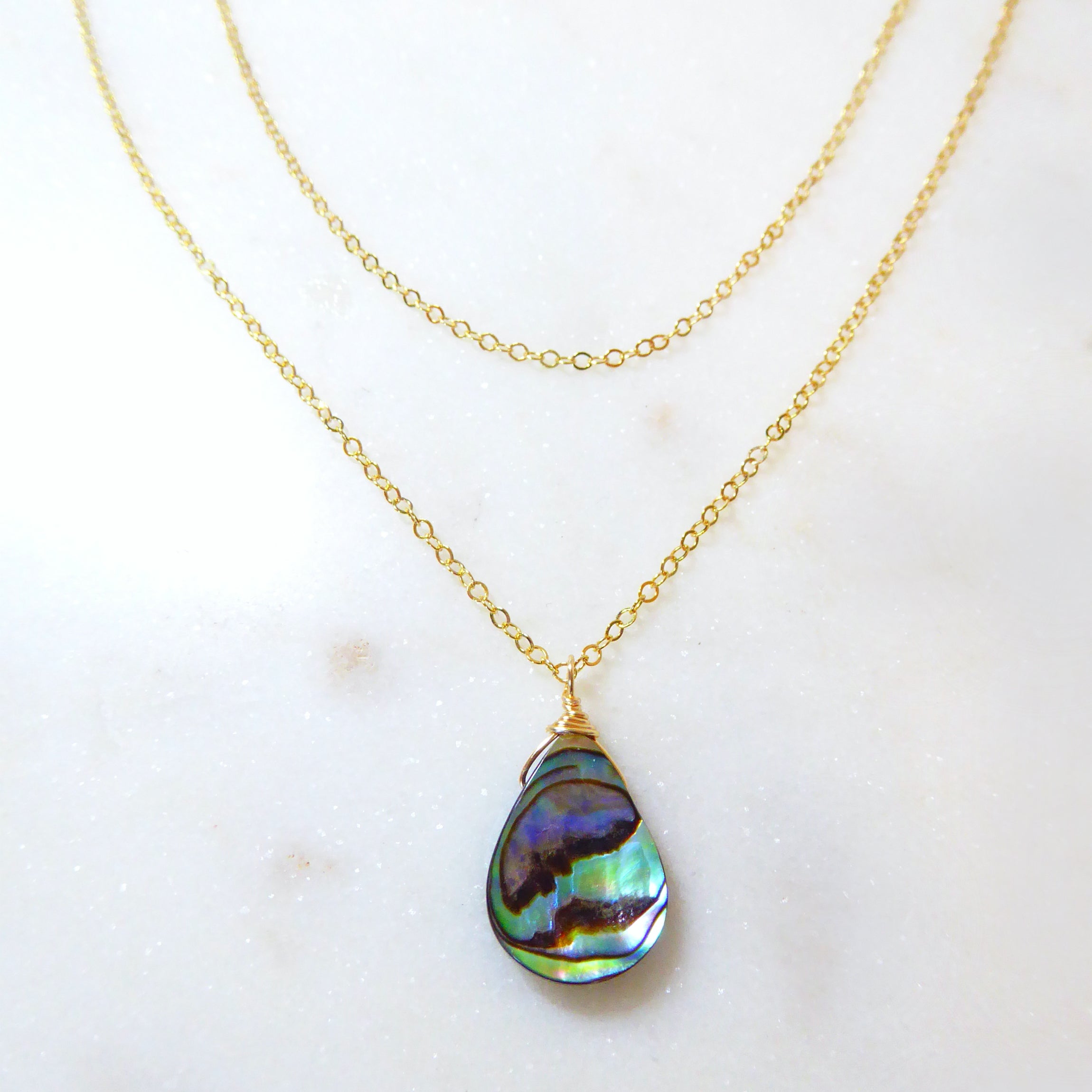 abalone layered multi strand pendant necklace on woman