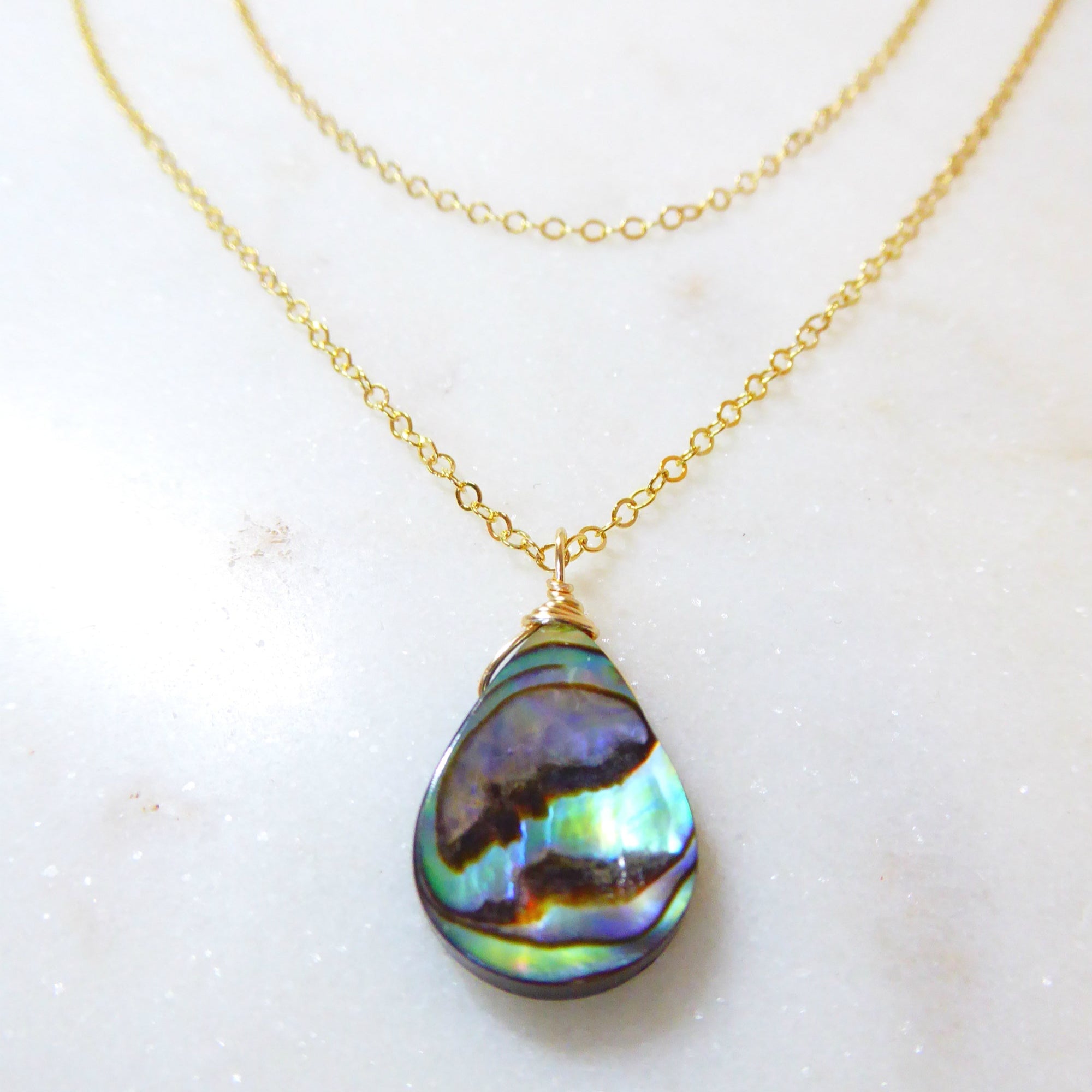 abalone layered multi strand pendant necklace on woman