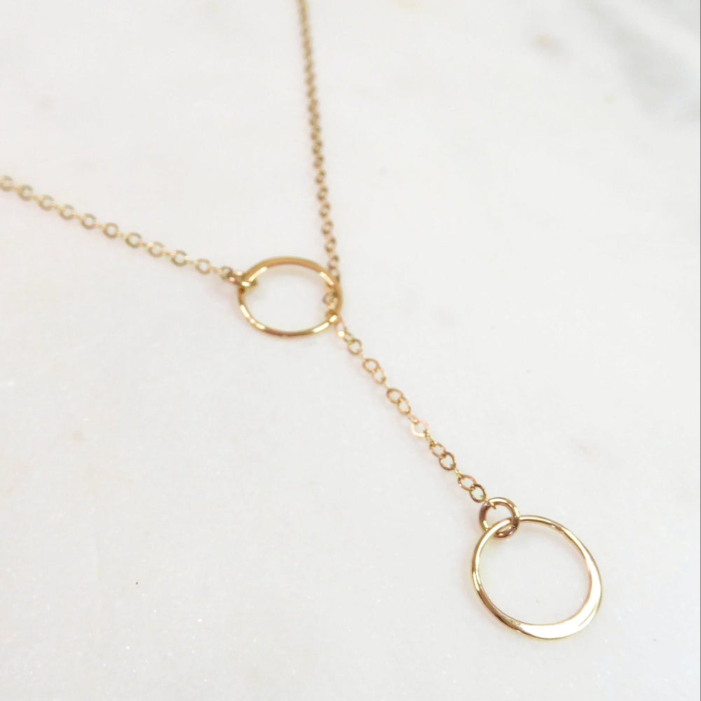 Gold necklace with circular pendants on a white background