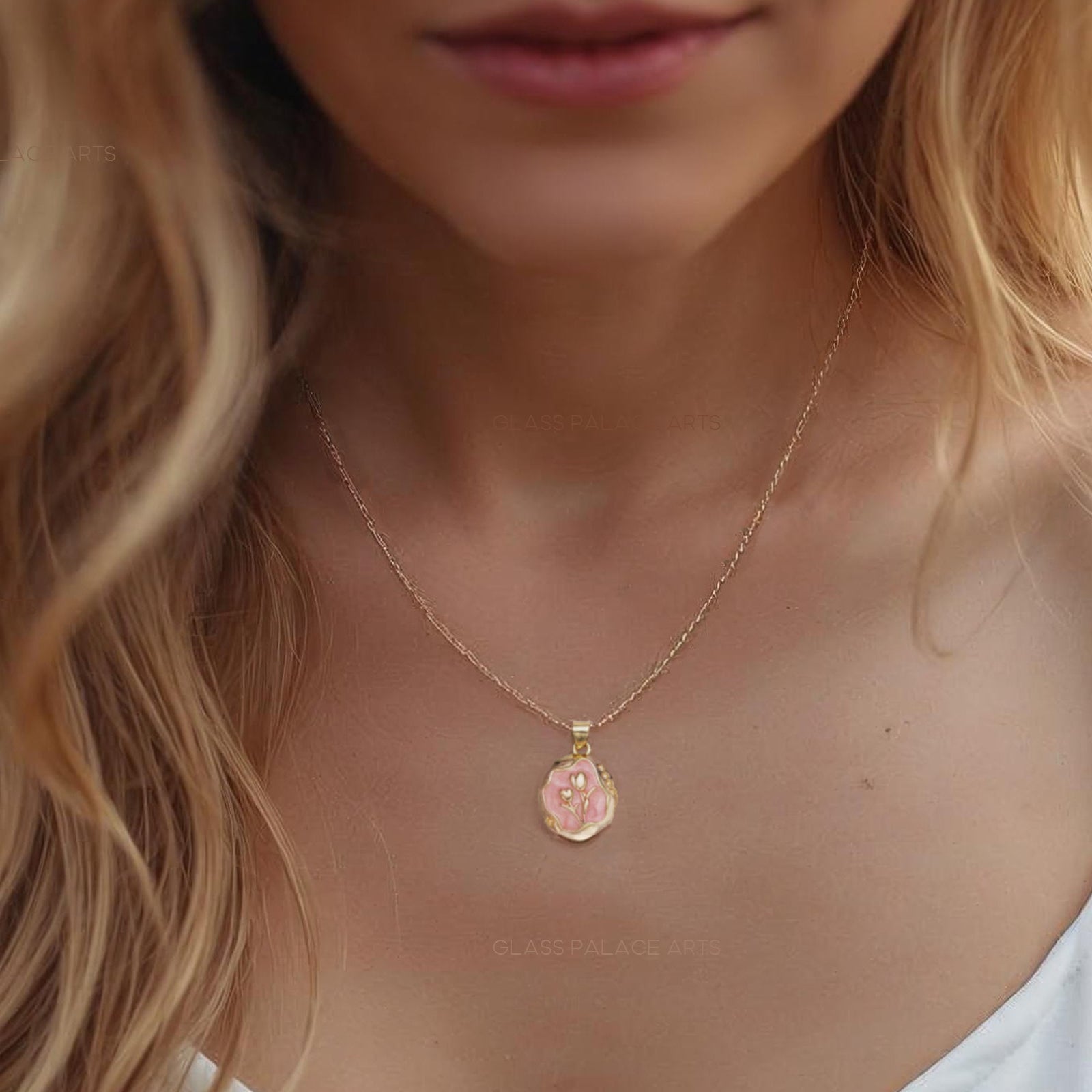 Woman wearing a gold necklace with a small pendant, blurred background