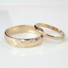 14k gold hammered wedding band set on white background