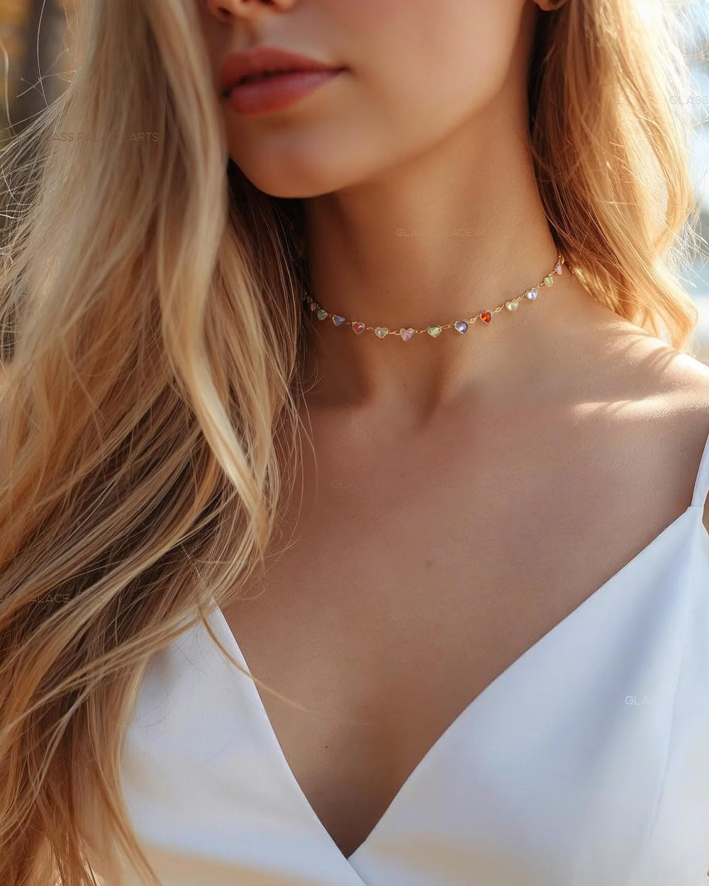 Close-up of a woman wearing a delicate heart multi colored gemstone choker necklace with a blurred background