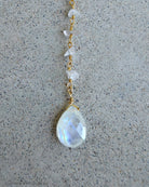 large moonstone focal pendant on gold chain with grey background