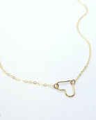 A delicate gold chain necklace featuring a small open heart pendant, displayed on a clean white background with a faint watermark in the lower-left corner.
