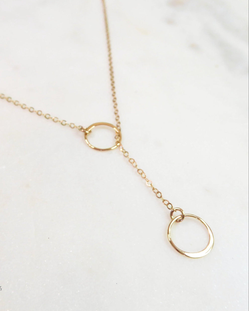 Gold necklace with circular pendants on a white background