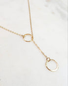 Gold necklace with circular pendants on a white background