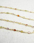 Gold chain with embedded multicolored gemstones on a white background