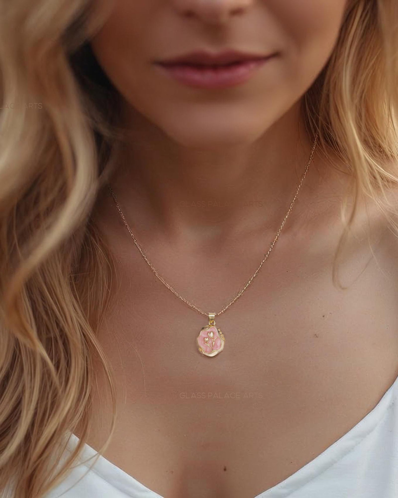Woman wearing a gold necklace with a small pendant, blurred background